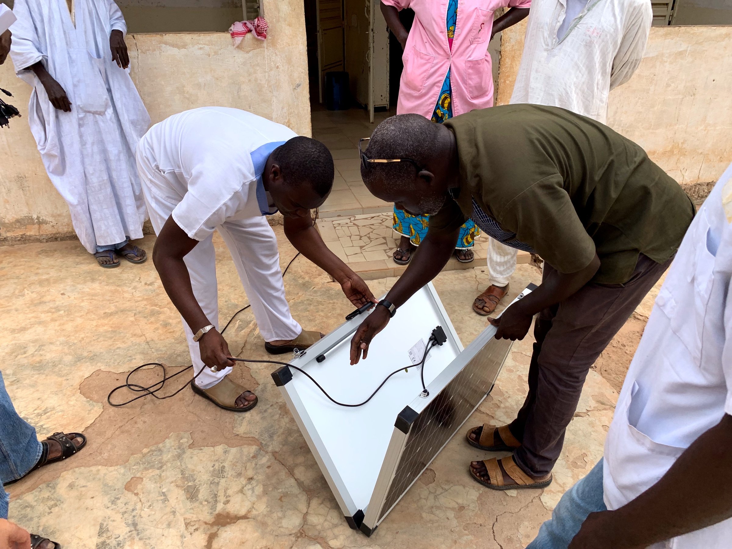 raccordement des câbles du panneau solaire pliable devant un poste de santé